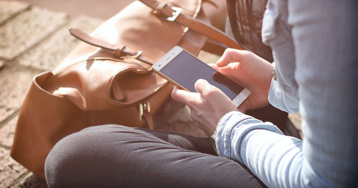 una persona che tiene in mano uno smartphone